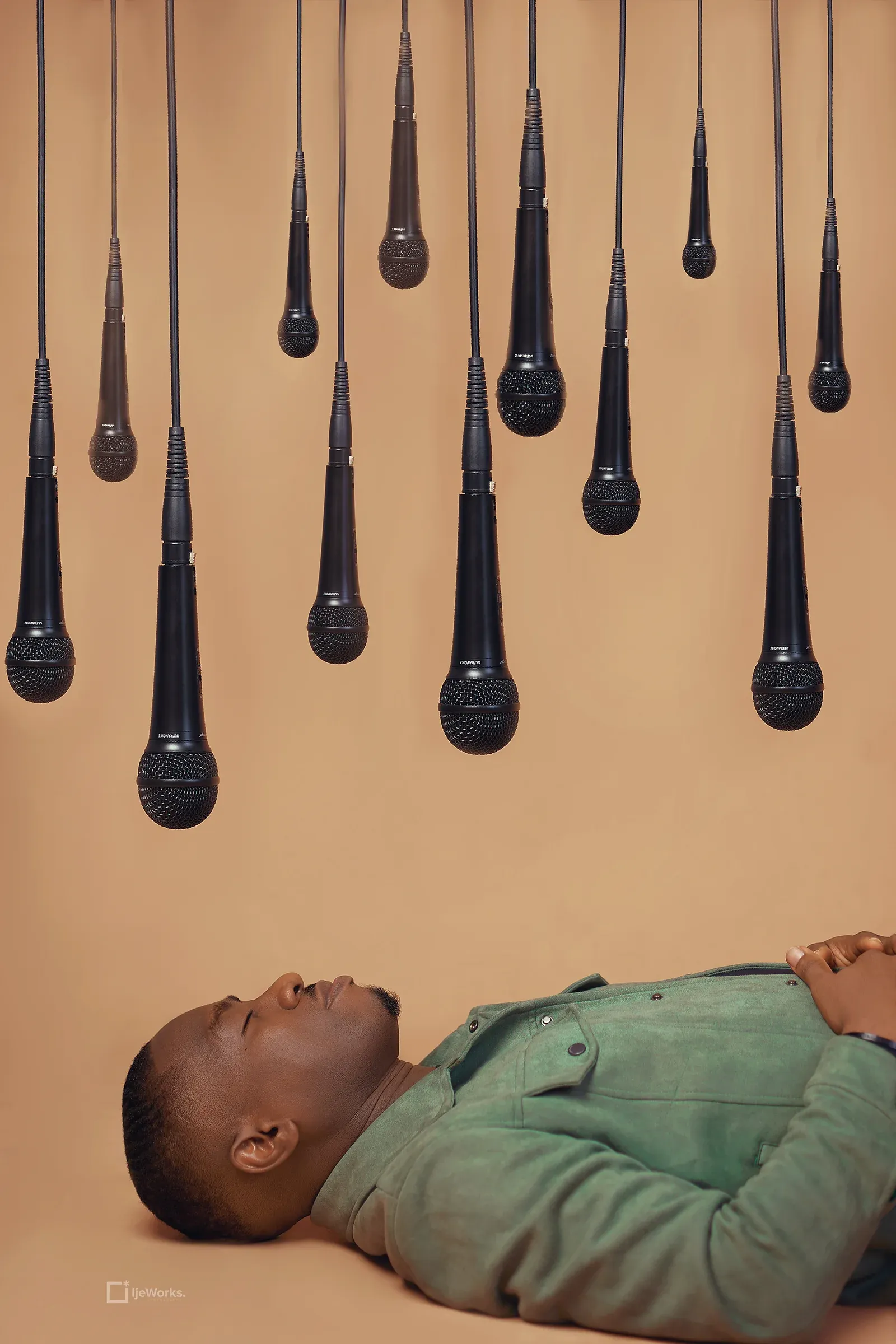 David Nkennor standing beneath suspended microphones.